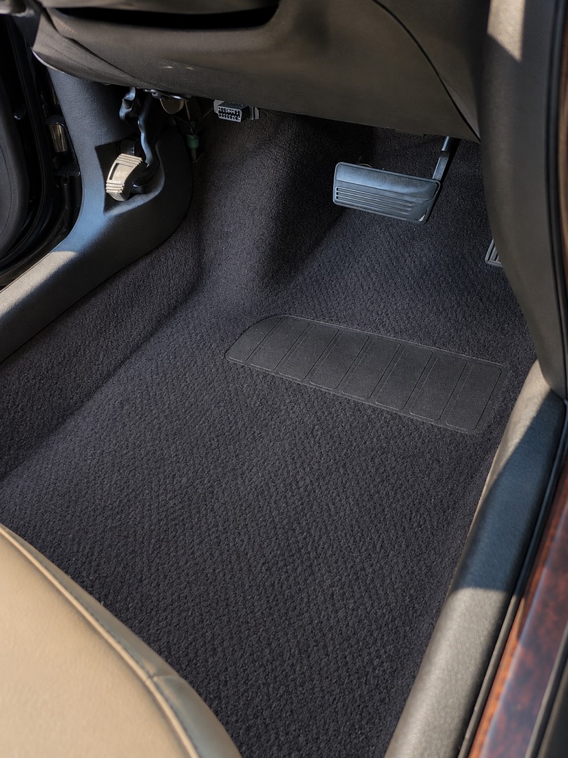 After: the same footwell shampooed back to clean black carpet