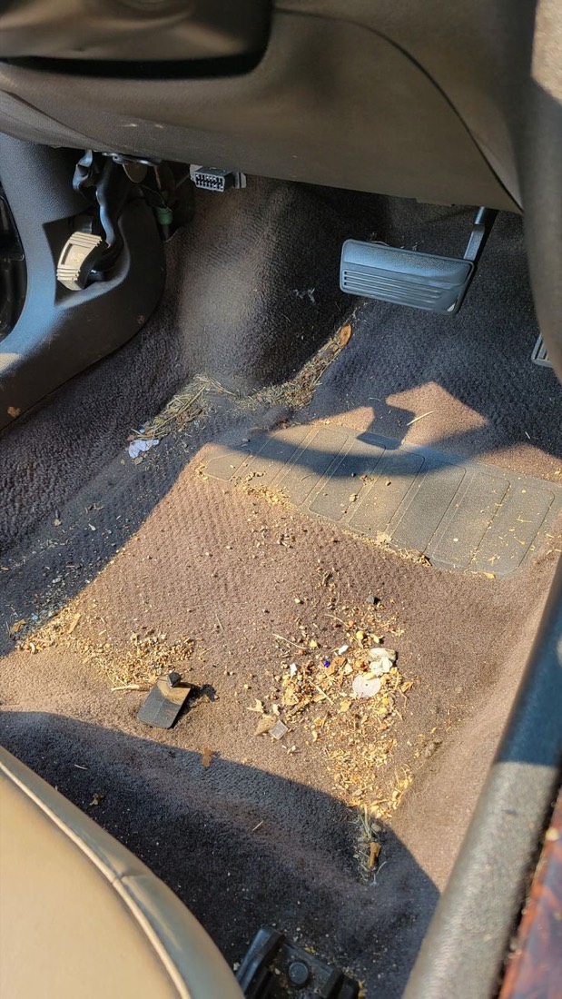 Before: driver footwell carpet caked with dried mud and debris