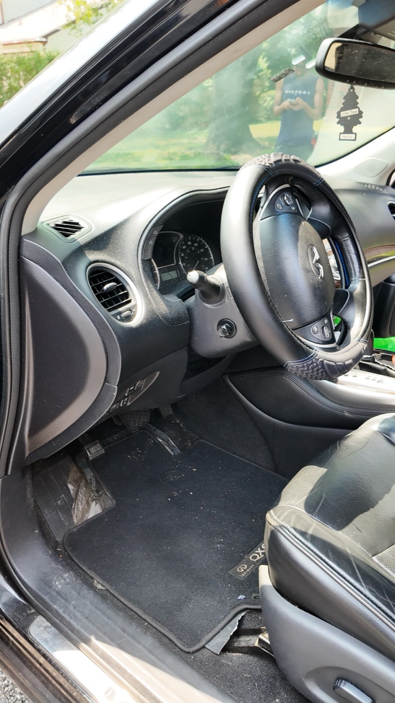 Before: Infiniti QX60 driver footwell and floor mat, soiled
