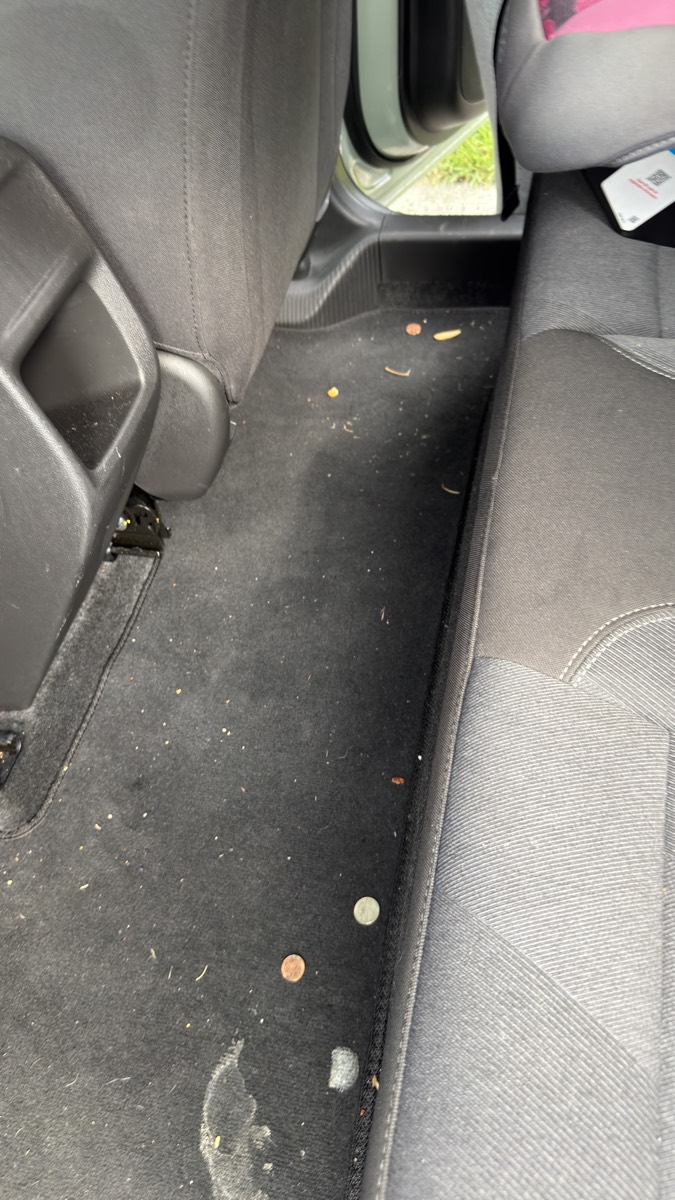 Before: rear footwell carpet littered with crumbs, coins and debris