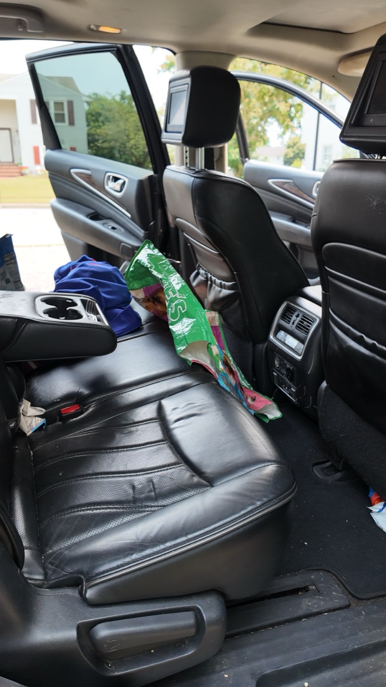 Before: rear leather seats cluttered with bags and belongings
