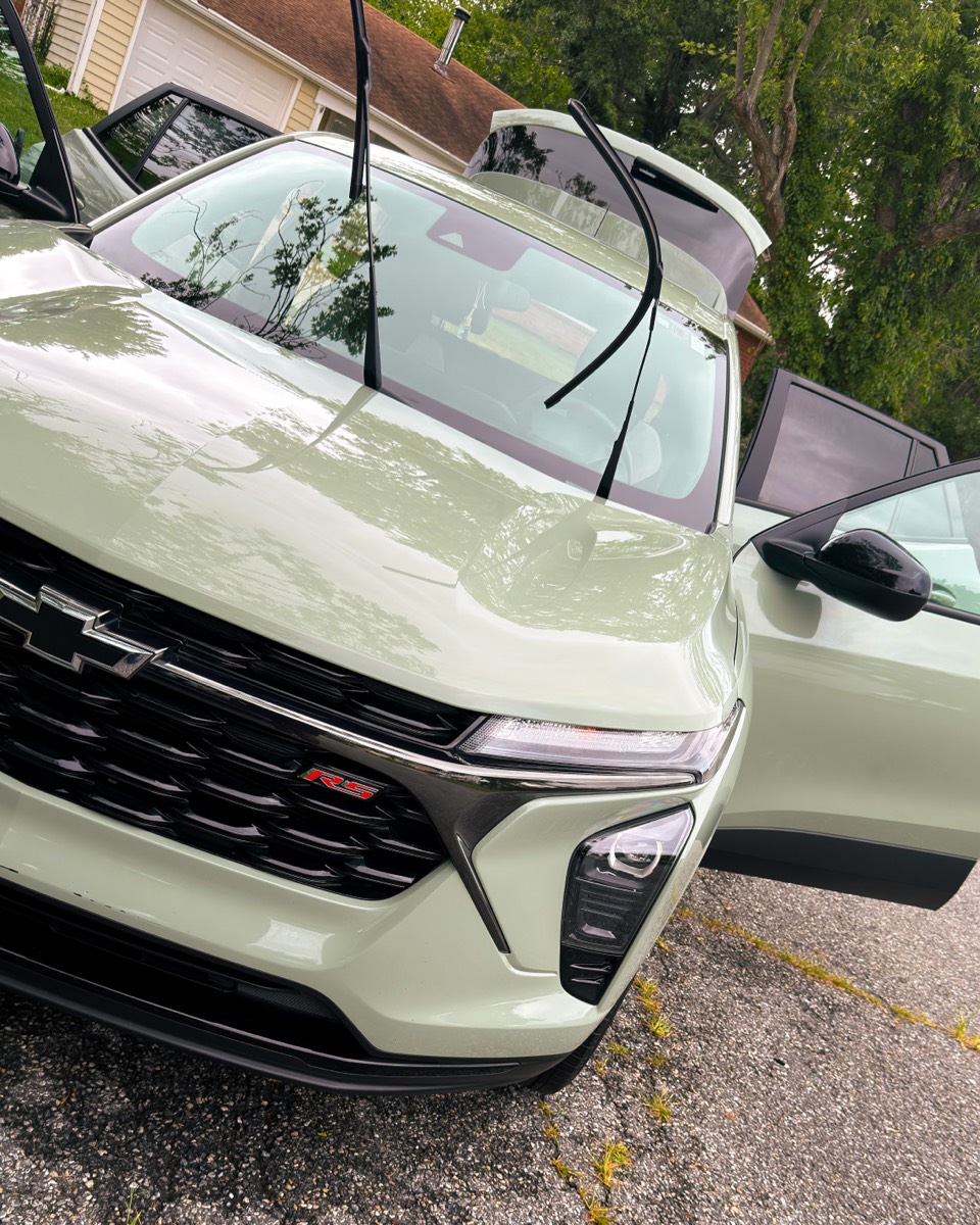 Polished hood and windshield of a sage-green Chevrolet Trax RS